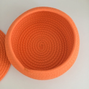 Top-down macro view of orange woven cotton rope storage basket with lid interior detail