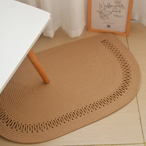 Detail of hand-woven cotton rope rug with scalloped edges for minimalist home decor