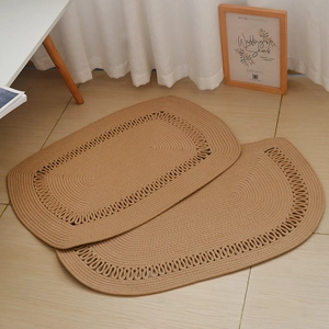 Detail of hand-woven cotton rope rugs featuring decorative looped edges and rustic texture