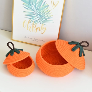 Detailed close-up of woven pumpkin-shaped cotton storage baskets with green lids