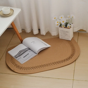 Detail of handwoven brown cotton rope rug with scalloped edges on light wood flooring