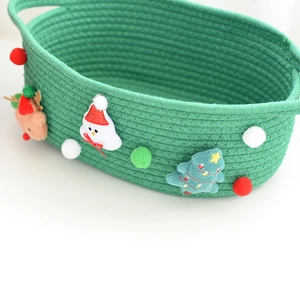 Detail of green cotton rope woven Christmas gift basket with 3D reindeer and snowman decor