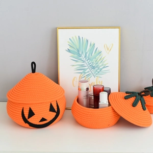 Detail of orange pumpkin cotton rope baskets with smiley face and green leaf lid