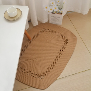 Handwoven oval cotton rope rug in warm camel brown with elegant hollow scalloped edges
