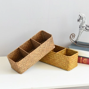 Close-up of seagrass woven storage baskets with multi-grid compartments and metal frames