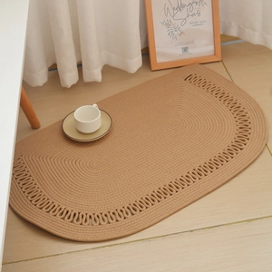 Detail of a half-round woven cotton rug with wavy scalloped edges and spiral texture