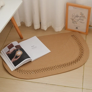 Detailed close-up of a semi-oval woven cotton rope rug with hollow edge patterns