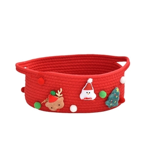 Red woven Christmas gift basket with Santa Claus reindeer patches and pom poms