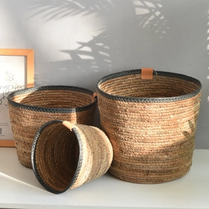 Three-piece Nordic woven storage baskets with leather handles and black fabric trim