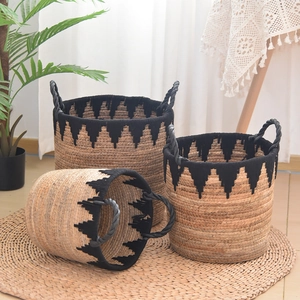 Set of three handmade straw storage baskets with black wavy patterns and sturdy handles