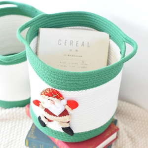 Détail du panier en coton vert avec Père Noël en peluche 3D et poignées latérales