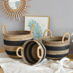 Detail of woven seagrass storage baskets with black stripes and sturdy handles