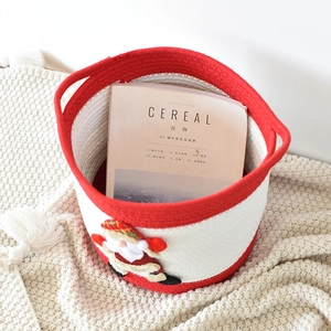 Vue détaillée d'un panier de Noël en coton tissé rouge et blanc avec motif du Père Noël