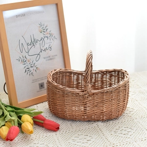 Detail of hand-woven wicker picnic basket with handle on white lace tablecloth background