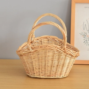 Close-up of a handmade willow storage basket with dual handles on a wooden table