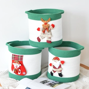 Détail de paniers de rangement en coton avec peluches de Père Noël, renne et bonhomme de neige
