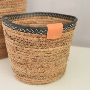 Detailed macro view of Nordic hand-woven storage basket with black trim and leather tag