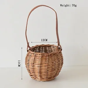 Detail of hand-woven wicker basket featuring a dark brown leather handle with gold rivets