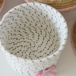 Dettaglio del cesto in corda di cotone intrecciato con fiocco rosa e piccoli pois