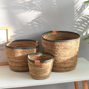 Set of three Nordic hand-woven seagrass baskets with leather detail and black trim