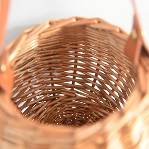 Macro shot of hand-woven wicker basket showing tight spiral texture and leather handle