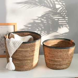 Nordic handmade seagrass storage baskets with leather handles and black stitched detailing
