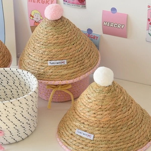 Dettaglio del cesto intrecciato con pompon rosa e fiocco giallo per decorazione casa