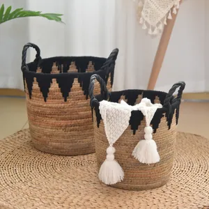 Detailed macro view of handmade seagrass storage baskets with black tassel fringe decoration