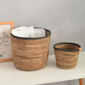 Set of two Nordic hand-woven seagrass baskets with black rim and leather handles