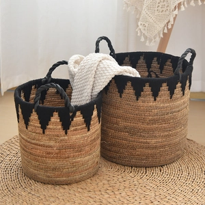 Detail of hand-woven seagrass baskets with black fringe and rustic rope handles