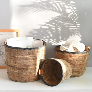 Three-piece nesting set of Nordic woven storage baskets with stylish brown leather handles