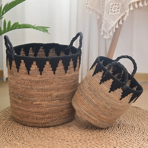 Close-up of handmade woven baskets showing natural straw texture and black wavy trim