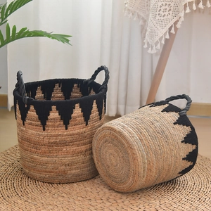 Detail view of handmade straw storage baskets with black tassels and rope handles