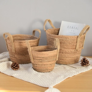 Macro detail of three-piece hand-woven straw baskets with handles for home storage decor