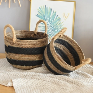 Detailed view of handmade wicker baskets with natural and black woven stripes on a rug