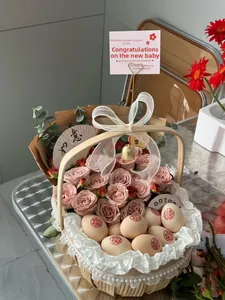 Detail of woven gift basket with pink roses, eucalyptus leaves, and decorated wedding eggs