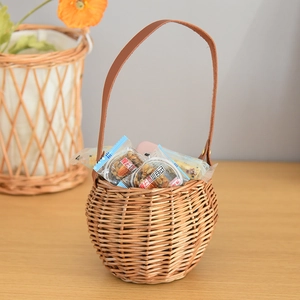 Close-up of wicker storage basket with brown leather handle and metal rivets detail