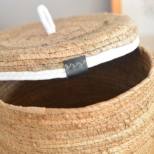 Handcrafted round rattan storage basket with lid and elegant leather handle detail