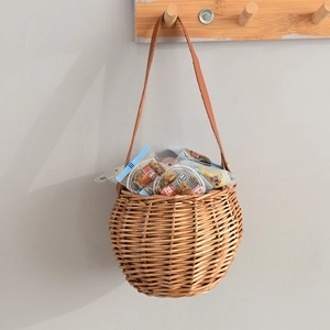 Detail of hand-woven wicker wall basket with brown leather handle and metal rivets