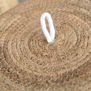 Detail of hand-woven wicker basket lid with natural texture and white handle loop