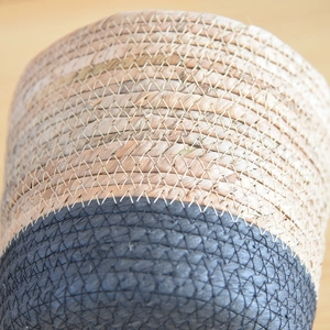 Close-up of dual-tone handwoven storage basket showing natural and navy blue textures