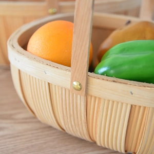 Close-up of hand-woven wooden fruit basket with metal rivets and sturdy handle