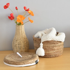 Close-up of hand-woven round basket with matching lid and rustic braided vase set