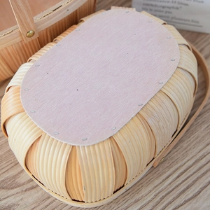 Close-up of the reinforced wooden base and metallic fasteners on the woven storage basket