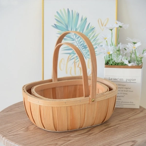 Detailed close-up of woven wood storage baskets in a two-piece nesting set with handles