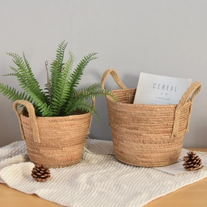 Detail of hand-woven straw planters with thick jute rope handles and natural fiber texture