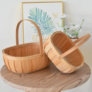 Detail of two-piece handwoven wooden picnic baskets with circular handles and gold rivets