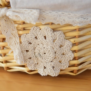 Close-up of handwoven wicker basket with beige lace trim and soft linen lining detail