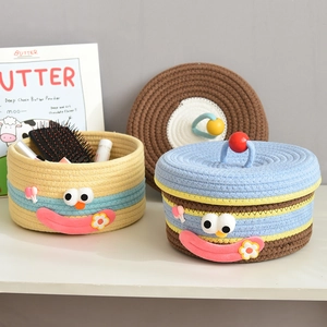 Close-up of woven cotton rope storage baskets with cartoon faces and flower details