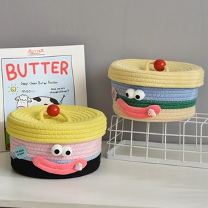 Detail of woven cotton rope storage basket with cartoon face and colorful stripes